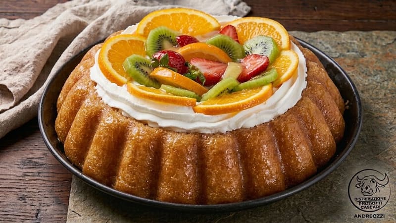 Una torta di babà farcita con crema e frutta fresca, vista dall'alto